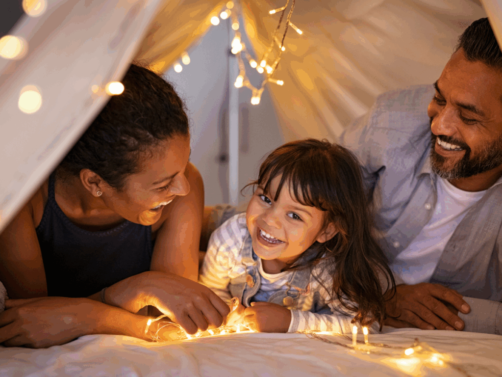 Mom, dad and daughter laying in a indoor tent