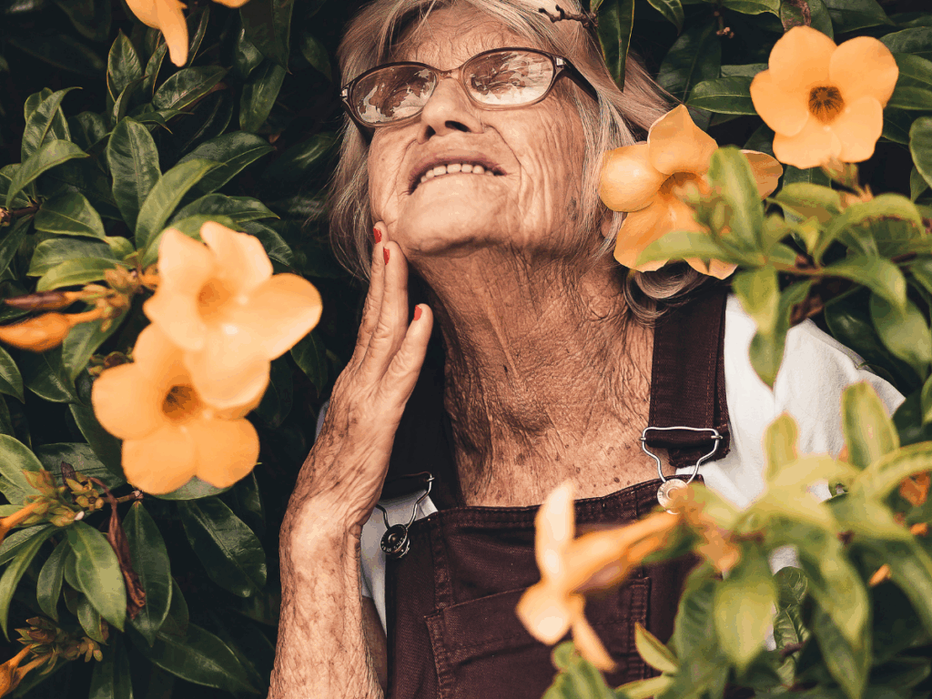Trendy female senior with flowers around her