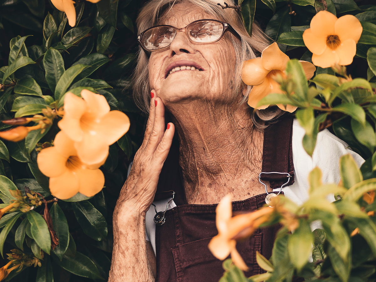 Trendy female senior with flowers around her